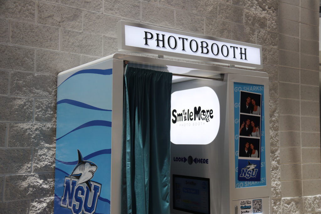 Close up of the SmileMore photo booth at Nova Southeastern University with NSU Sharks wrap and teal curtain